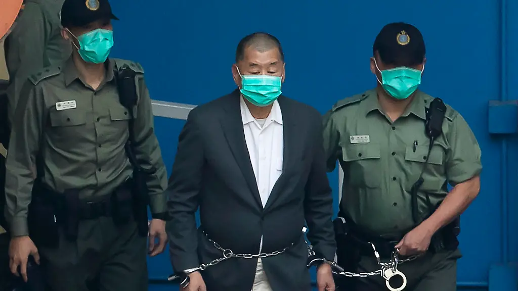 FILE-Jimmy-Lai-who-founded-the-Apple-Daily-is-escorted-by-Correctional-Services-officers-to-get-on-a-prison-van-before-appearing-in-a-court-in-Hong-Kong-Dec-12-2020-China-s-Foreign-Ministry-has-condemned-a-resolution-passed-by-the-European-Parliament-criticizing-the-Hong-Kong-s-shrinking-rights-to-free-speech-and-political-participation-and-urged-the-city-s-government-to-release-and-drop-all-charges-against-activist-publisher-Jimmy-Lai-a-sign-of-continuing-political-tensions-between-the-sides-even-as-they-seek-to-restore-economic-links