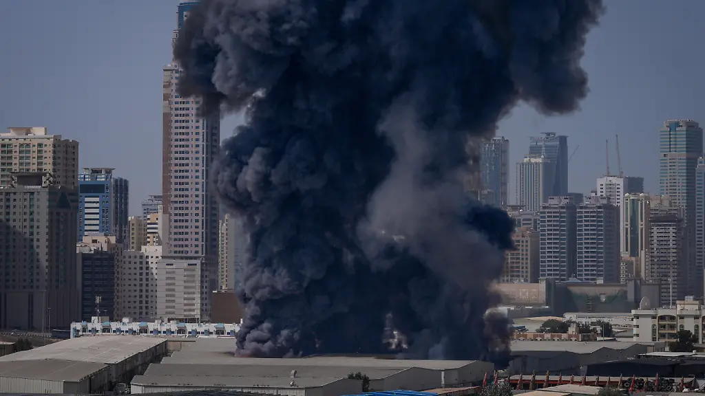 Eine-schwarze-Rauchwolke-steigt-aus-einem-Lagerhaus-im-Industriegebiet-von-Sharjah-City-in-den-Vereinigten-Arabischen-Emiraten-auf-nachdem-ueber-iranische-Angriffe-berichtet-wurde