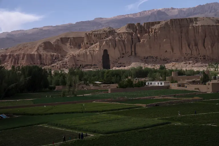Villagers-walk-in-the-fields-near-the-niche-of-the-giant-Buddha-statue-destroyed-by-the-Taliban-in-2001-in-Bamiyan-Afghanistan-Saturday-June-17-2023