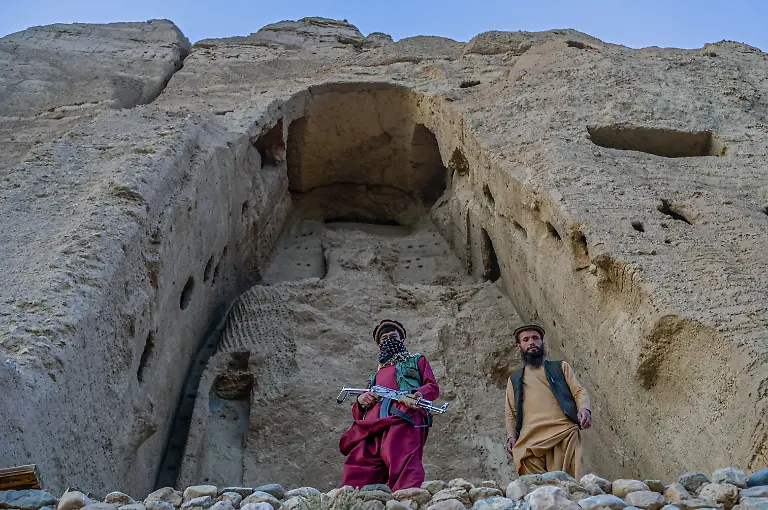 Members-of-Taliban-stand-in-front-of-the-site-where-the-Shahmama-Buddha-statue-once-stood-before-being-destroyed-by-the-Taliban-in-March-2001-in-Bamiyan-province-on-October-2-2021-In-the-world-renowned-Bamiyan-valley-of-central-Afghanistan-Taliban-gunmen-stand-guard-by-the-vast-cavities-that-once-housed-two-famous-Buddhas-blown-up-by-the-Islamists-leaders-20-years-ago