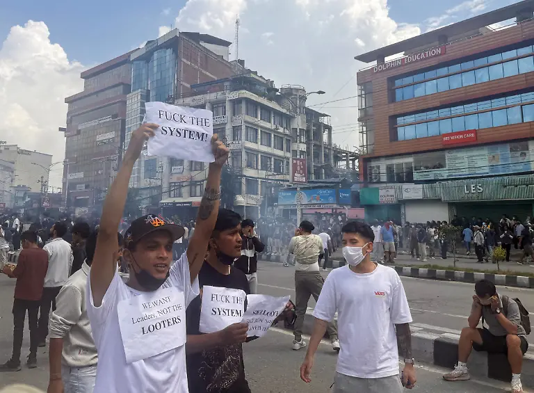 SENSITIVE-MATERIAL-THIS-IMAGE-MAY-OFFEND-OR-DISTURB-Rashik-Khatiwada-23-holding-a-placard-that-reads-FUCK-THE-SYSTEM-takes-part-in-Nepal-s-youth-led-protests-that-toppled-the-prime-minister-before-he-was-shot-dead-near-the-Parliament-building-in-Kathmandu-Nepal-September-8-2025-On-the-afternoon-of-September-8-last-year-Rashik-Khatiwada-stood-near-Nepal-s-parliament-building-surrounded-by-hundreds-of-others-rallying-against-corruption-and-unemployment-Within-two-hours-the-23-year-old-student-had-been-shot-dead-REUTERS-Sahana-Bajracharya-SEARCH-CHITRAKAR-NEPAL-PROTESTER-FAMILIES-FOR-THIS-STORY-SEARCH-WIDER-IMAGE-FOR-ALL-STORIES