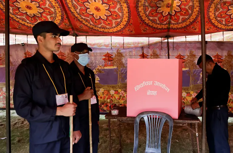 Security-personnel-stand-guard-as-a-polling-official-sets-up-a-polling-station-ahead-of-general-election-in-Lalitpur-Nepal-March-4-2026