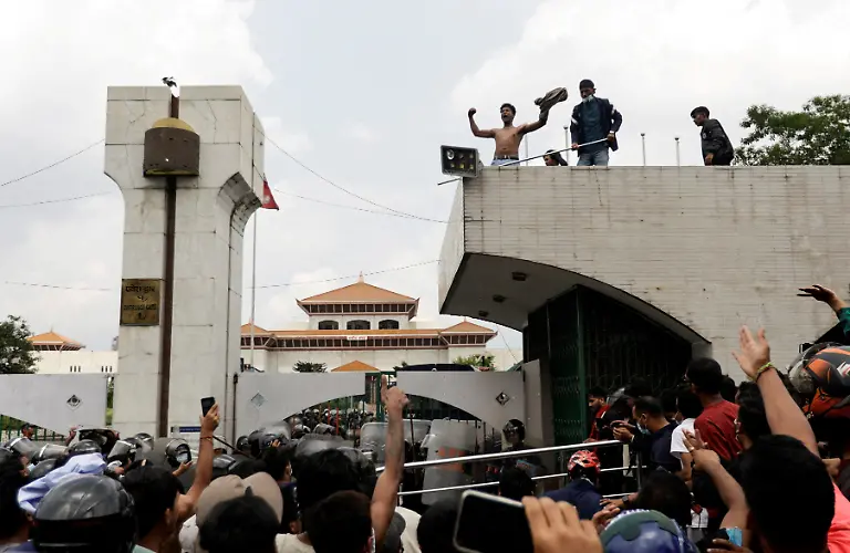 Demonstrators-shout-slogans-as-they-stand-atop-the-entrance-of-Parliament-during-youth-led-protests-that-toppled-the-Nepal-s-prime-minister-in-Kathmandu-Nepal-September-8-2025-77-people-were-killed-in-two-days-of-protests-that-later-forced-the-resignation-of-then-Prime-Minister-K-P-Sharma-Oli-and-shook-up-Nepal-s-broken-political-system-A-state-appointed-commission-charged-with-conducting-an-investigation-into-the-protests-including-the-use-of-live-ammunition-against-young-demonstrators-has-received-three-extensions-to-complete-the-probe-Its-final-findings-are-expected-to-be-released-after-the-general-election-set-for-March-5-2026-REUTERS-Navesh-Chitrakar-SEARCH-CHITRAKAR-NEPAL-PROTESTER-FAMILIES-FOR-THIS-STORY-SEARCH-WIDER-IMAGE-FOR-ALL-STORIES