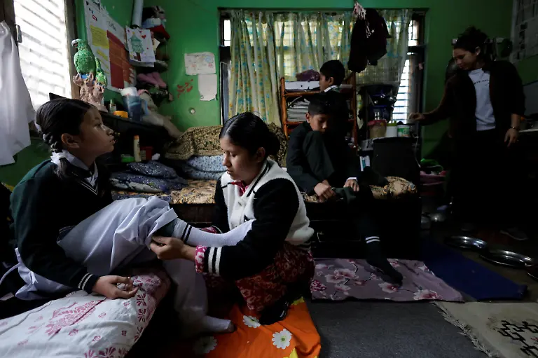 Parbati-Subedi-28-wife-of-Dev-Kumar-Subedi-29-who-was-shot-dead-during-youth-led-protests-that-toppled-Nepal-s-prime-minister-and-prompted-elections-set-for-March-5-2026-helps-her-daughter-Saloni-Subedi-get-ready-for-school-in-Lalitpur-Nepal-February-23-2026-Subedi-has-received-the-1-5-million-rupees-compensation-that-an-interim-government-has-provided-to-the-families-of-42-of-the-77-killed-that-it-declared-martyrs-I-believe-this-protest-happened-because-people-wanted-change-in-Nepal-and-change-in-our-leaders-Subedi-said-Those-in-power-forgot-about-families-like-ours-for-whom-putting-two-meals-on-the-table-is-a-daily-struggle-REUTERS-Navesh-Chitrakar-SEARCH-CHITRAKAR-NEPAL-PROTESTER-FAMILIES-FOR-THIS-STORY-SEARCH-WIDER-IMAGE-FOR-ALL-STORIES