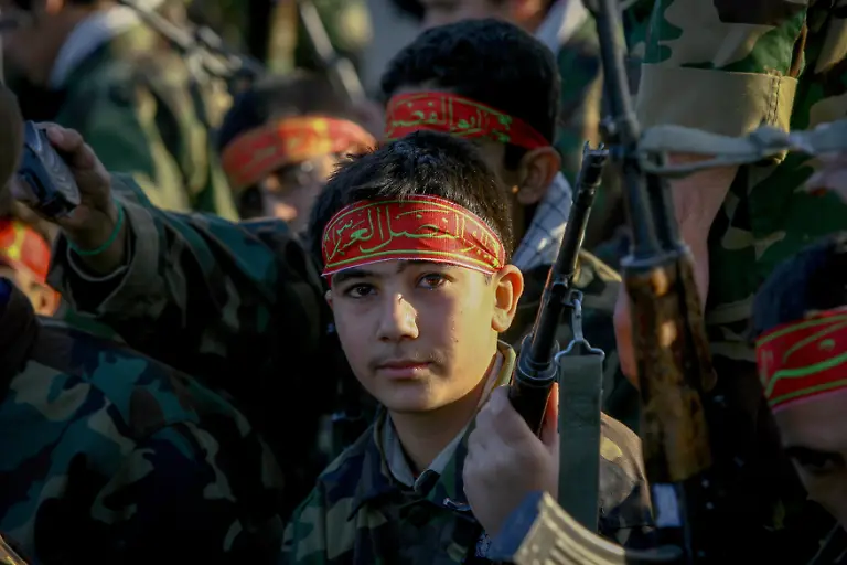Young-Iranian-members-of-the-Basij-militia-sit-during-a-military-parade-to-mark-the-national-Basij-Week-at-a-military-base-of-Iran-s-elite-Revolutionary-Guards-in-northeastern-Tehran-on-November-25-2008-Established-in-1979-by-order-of-the-late-Supreme-Leader-Ayatollah-Ruhollah-Khomeini-the-Basij-is-a-paramilitary-volunteer-militia-and-one-of-five-branches-of-the-Islamic-Revolutionary-Guard-Corps-IRGC