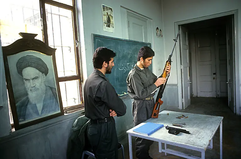 A-Revolutionary-Guard-conducts-an-arms-training-session-with-a-Russian-Dragunov-sniper-rifle-in-a-classroom-at-the-former-US-embassy-in-Tehran-25th-September-1994-After-the-seizure-of-the-embassy-by-revolutionary-students-in-1979-and-the-subsequent-Iran-Hostage-Crisis-the-building-was-used-as-an-elite-military-academy-until-the-late-1990s-On-the-left-is-a-portrait-of-Ayatollah-Khomeini