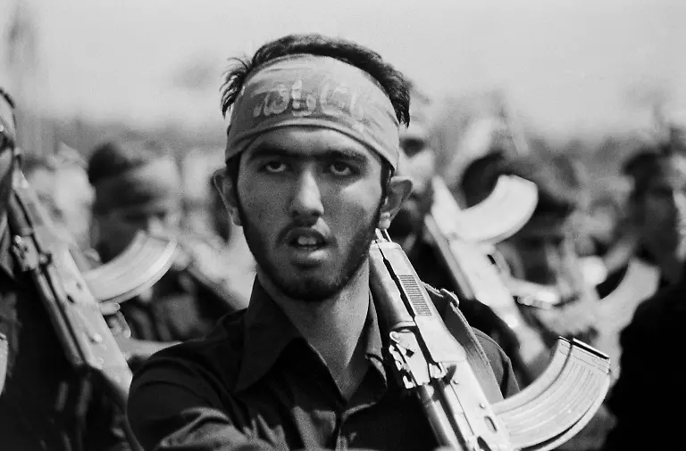 Tehran-Iran-A-young-Basiji-mobilized-volunteer-forces-man-carrying-an-AK-47-and-wearing-a-headband-with-Islamic-slogan-marches-on-the-anniversary-of-the-Iran-Iraq-war-in-Azadi-square-in-Tehran-21st-September-1982