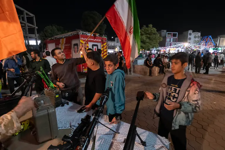 Young-Iranian-men-look-at-guns-while-participating-in-a-ceremony-commemorating-the-45th-anniversary-of-the-Iran-Iraq-war-1980-88-and-the-12-day-war-between-Iran-and-Israel-in-a-park-in-Malard-county-in-the-south-of-Tehran-Iran-on-September-25-2025
