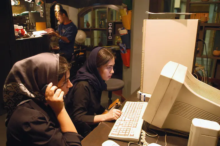 Tehran-Iran-Two-young-ladies-use-a-chat-room-making-an-appointment-with-friends-in-a-coffee-shop