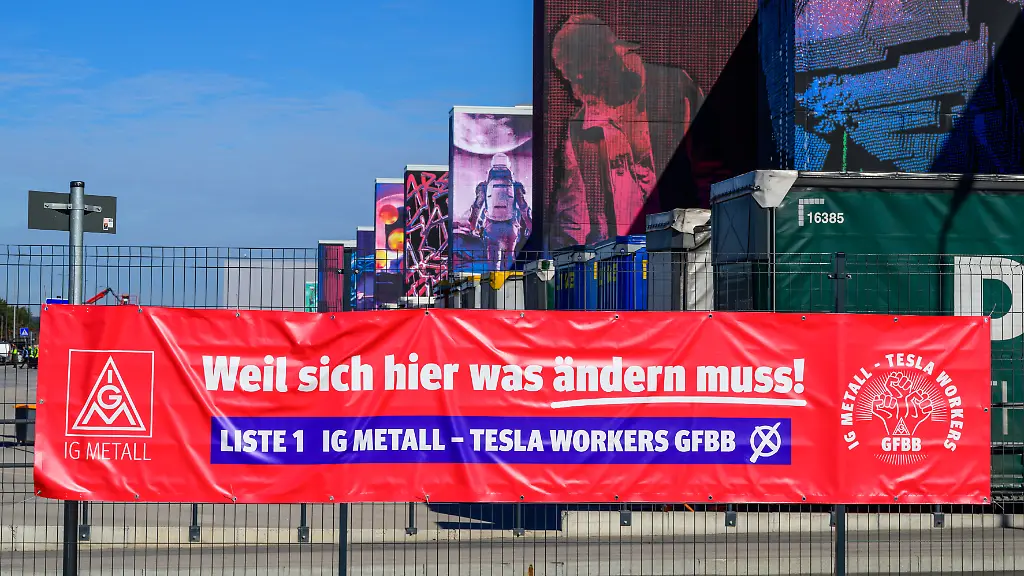 Ein-Werbetransparent-der-IG-Metall-zur-Betriebsratswahl-haengt-an-einem-Zaun-der-Tesla-Gigafactory-Berlin-Brandenburg-Im-einzigen-deutschen-Autowerk-von-Tesla-beginnt-am-Montag-die-mit-Spannung-erwartete-Betriebsratswahl