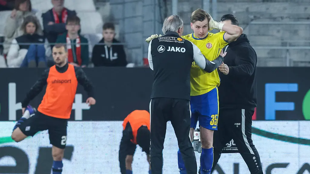 Fussball-3-Liga-27-Spieltag-Rot-Weiss-Essen-SV-Waldhof-Mannheim-am-04-03-2026-im-Stadion-an-der-Hafenstrasse-in-Essen-Felix-Wienand-Essen-haelt-sich-den-Kopf-nach-einem-lauten-Knall-Pyrotechnik-auf-dem-Spielfeld-DFB-regulations-prohibit-any-use-of-photographs-as-image-sequences-and-or-quasi-video