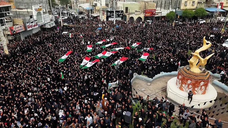 An-aerial-view-of-mourners-carrying-Iranian-flags-and-portraits-as-they-gather-during-a-funeral-ceremony-for-children-who-lost-their-lives-after-a-primary-school-in-Iranas-Hormozgan-province-was-targeted-in-US-and-Israeli-attacks-on-March-03-2026-in-Minab-Iran-Thousands-of-people-including-families-and-officials-attended-the-ceremony-Photo-by-Stringer-Parspix-ABACAPRESS