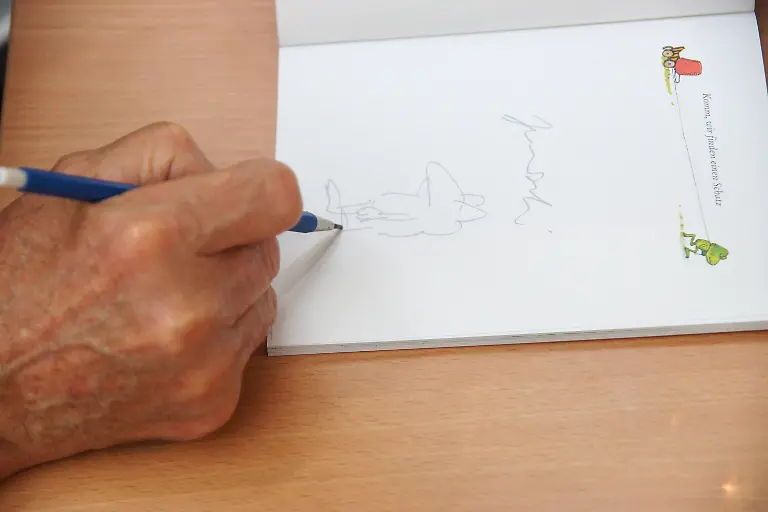 Janosch-Horst-Eckert-deutscher-Illustrator-Zeichner-und-Schriftsteller-signiert-eines-seiner-Buecher-in-der-Galerie-Griesshaber-Tuebingen-Baden-Wuerttemberg-Deutschland-Janosch-Horst-Eckert-German-Illustrator-Draftsman-and-Writer-signed-one-its-Books-in-the-Gallery-Griesshaber-Tuebingen-Bathing-Wuerttemberg-Germany