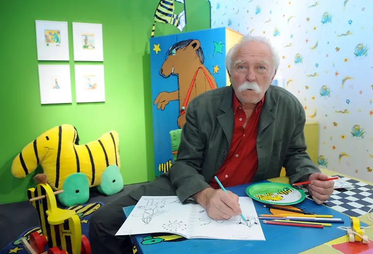 ARCHIV-Der-Zeichner-und-Erzaehler-Janosch-sitzt-in-einem-nachgebildeten-Kinderzimmer-am-Freitag-26-06-2009-in-Aachen-Am-11-Maerz-wird-der-beruehmte-Schriftsteller-85-Jahre-alt-Foto-Joerg-Carstensen-dpa-zu-dpa-Janosch-feiert-seinen-85-Geburtstag-mit-Wein-Fisch-und-Gesang-vom-10-03