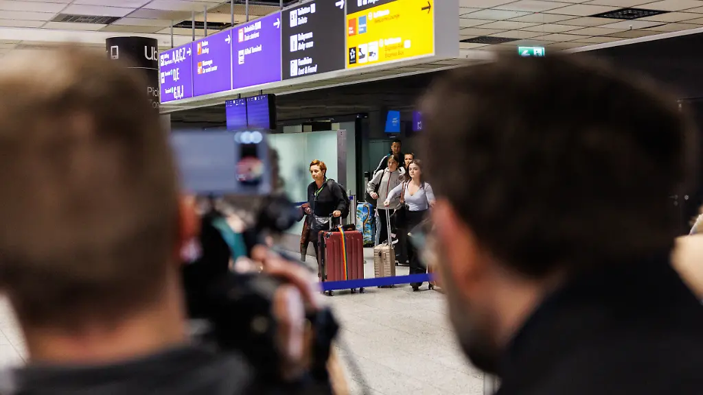 Menschen-kommen-aus-dem-Ankunftsbereich-nach-ihrer-Ankunft-am-Frankfurter-Flughafen-Der-erste-Evakuierungsflug-im-Auftrag-der-Bundesregierung-ist-am-fruehen-Donnerstagmorgen-am-Frankfurter-Flughafen-gelandet