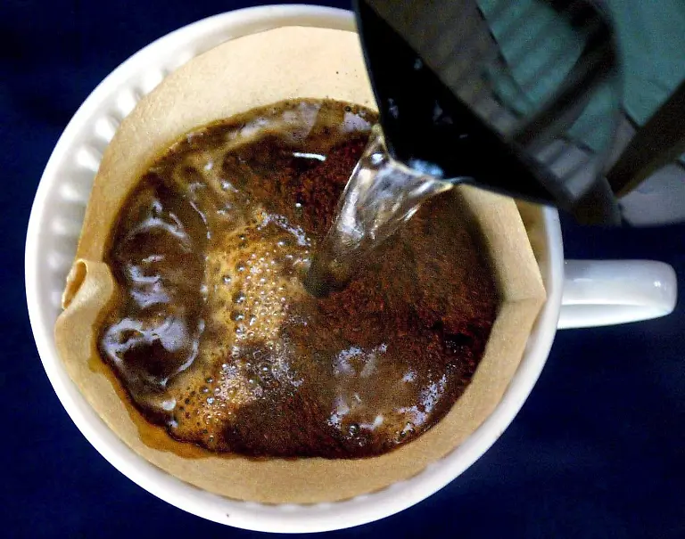 epa00886305-FILES-Hot-water-is-poured-into-a-Melitta-coffee-filter-in-Duesseldorf-on-16-February-2004-The-first-paper-coffee-filter-in-1908-was-made-by-German-homemaker-Melitta-Benz-The-blotting-paper-in-her-son-s-exercise-book-gave-her-the-initial-idea-for-her-invention-Paper-is-a-material-produced-by-the-amalgamation-of-plant-fibres-that-can-be-used-for-a-large-variety-of-purposes-in-arts-and-industries