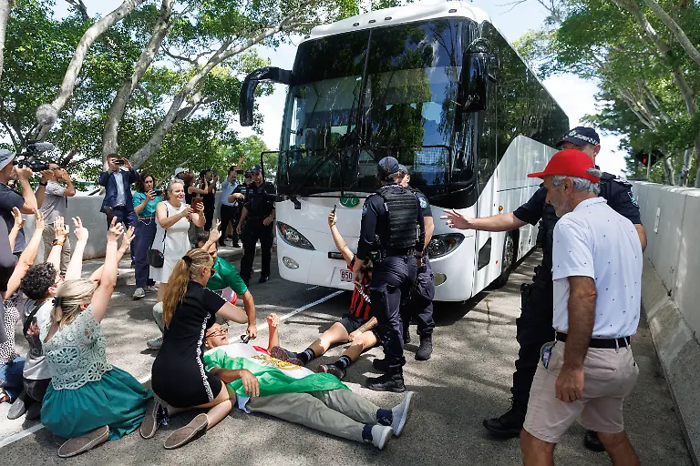 Demonstranten-protestieren-vor-dem-Royal-Pines-Resort-waehrend-ein-Bus-mit-iranischen-Spielerinnen-und-Mitarbeitern-abfaehrt-Fuenf-iranische-Fussballerinnen-haben-humanitaere-Visa-in-Australien-erhalten-Der-Rest-des-Teams-verliess-am-Nachmittag-Ortszeit-aber-das-Hotel-in-Richtung-Flughafen