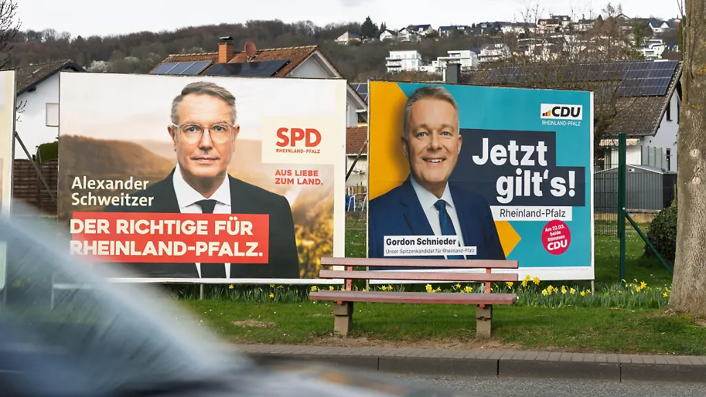 Grossflaechen-Wahlplakate-der-SPD-mit-Ministerpraesident-Alexander-Schweitzer-links-und-der-CDU-mit-Spitzenkandidat-Gordon-Schnieder-rechts-zur-Landtagswahl-in-Rheinland-Pfalz-am-22-03-2026-Die-Plakate-stehen-nebeneinander-am-Rheinufer-an-der-B42-in-Erpel-Landkreis-Neuwied