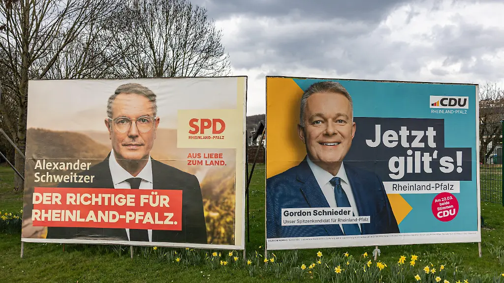 Grossflaechen-Wahlplakate-der-SPD-mit-Ministerpraesident-Alexander-Schweitzer-links-und-der-CDU-mit-Spitzenkandidat-Gordon-Schnieder-rechts-zur-Landtagswahl-in-Rheinland-Pfalz-am-22-03-2026-Die-Plakate-stehen-nebeneinander-am-Rheinufer-an-der-B42-in-Erpel-Landkreis-Neuwied