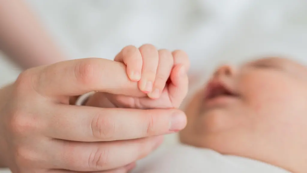 Happy-family-Tiny-newborn-infant-baby-little-hand-on-mother-hand-palm-Newborn-baby-holding-parent-finger-after-birth-Mom-baby-at-home-Support-protection-of-new-life