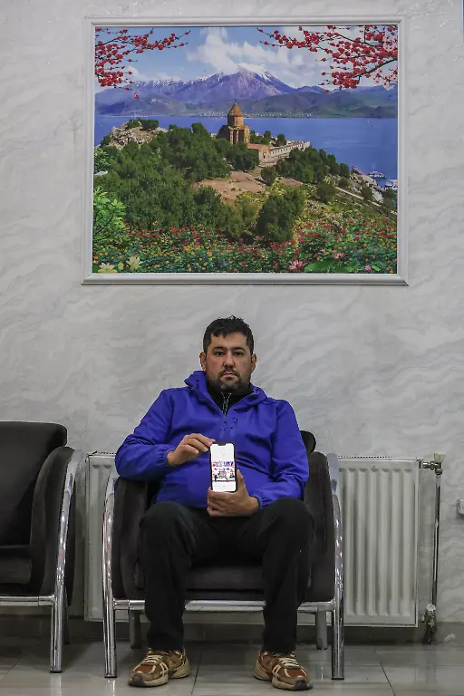 Hamid-Shirmohammadzadeh-35-who-arrived-in-Turkey-from-Iran-poses-for-a-portrait-while-holding-a-mobile-phone-displaying-a-picture-of-his-children-at-the-hotel-where-he-is-staying-in-Van-province-Turkey-March-5-2026-He-had-been-building-a-life-in-Tokyo-working-for-an-import-export-company-When-his-work-visa-expired-in-February-he-returned-to-Tehran-where-his-wife-and-two-children-aged-nine-and-ten-had-been-living-They-are-now-waiting-near-the-border-in-Iran-while-he-tries-to-secure-visas-from-Japanese-authorities-so-they-can-join-him-abroad-REUTERS-Dilara-Senkaya-SEARCH-SENKAYA-IRAN-CRISIS-TURKEY-BORDER-FOR-THIS-STORY-SEARCH-WIDER-IMAGE-FOR-ALL-STORIES
