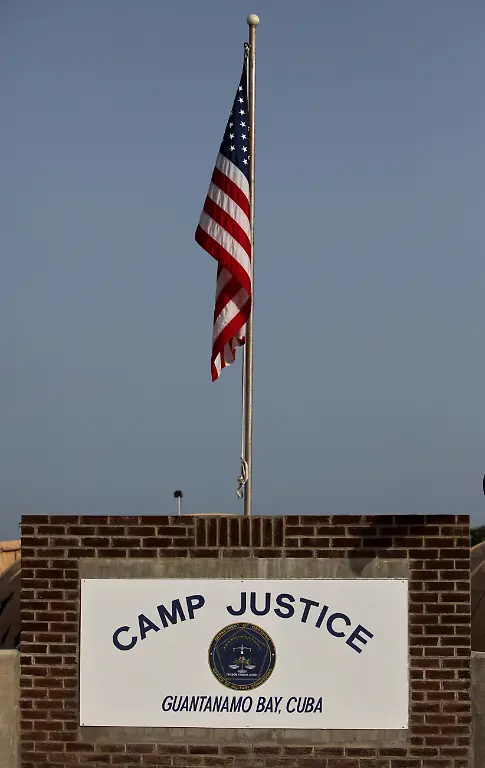 In-this-photo-reviewed-by-the-U-S-military-a-US-flag-hangs-above-the-sign-marking-the-Camp-Justice-compound-the-site-of-the-U-S-war-crimes-tribunal-on-Guantanamo-Bay-U-S-Naval-Base-in-Cuba-Thursday-July-16-2009-Hearings-in-four-separate-cases-are-being-held-Wednesday-and-Thursday-including-the-case-titled-U-S-vs-Mohammed-which-includes-Khalid-Sheikh-Mohammed-an-alleged-mastermind-of-the-2001-attacks