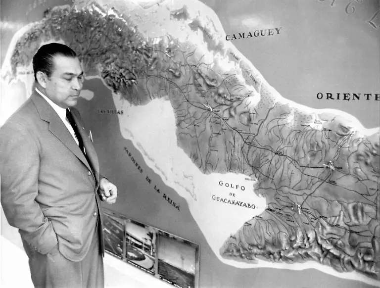 Der-kubanische-Diktator-erlaeutert-am-7-April-1958-in-Havanna-vor-Journalisten-anhand-einer-Karte-wo-seine-Regierungstruppen-die-Guerillas-um-Fidel-Castro-angeblich-entdeckt-und-isoliert-haben-Fulgencio-Batista-war-von-1940-1944-kubanischer-Diktator-1952-uebernahm-er-nach-einem-Putsch-erneut-die-Macht-und-fungierte-als-Staatspraesident-des-mittelamerikanischen-Inselstaates-bis-er-im-Januar-1959-vor-den-Truppen-des-Guerilla-Fuehrers-Fidel-Castro-ins-Exil-fluechtete-Fulgencio-Batista-y-Zaldivar-wurde-am-16-Januar-1901-in-Banes-geboren-und-ist-am-6-August-1973-in-Marbella-Spanien-gestorben