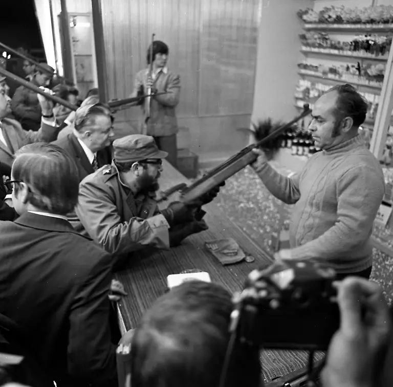 Dresden-historisch-DDR-Politik-Staatsbesuch-Fidel-Castro-Staatspraesident-Kuba-und-Erster-Sekretaer-des-Zentralkomitees-der-Kommunistischen-Partei-Kubas-16-06-1972-in-der-Stadt-Empfang-am-15-06-1972-in-Churfuerstliche-Waldschaenke-in-Moritzburg-Dort-sind-eine-Buehne-und-Staende-aufgebaut-wie-bei-einem-kleinen-Volksfest-Es-gab-Meissner-Wein-und-Radeberger-Pilsner-beides-vom-Fass-sowie-Wild-Reh-und-Muffelwild-am-Spiess-Ausserdem-zeigt-Castro-an-der-Schiessbude-seine-Fertigkeiten-mit-dem-Luftqewehr-Berichte-in-der-Saechsischen-Zeitung-am-17-06-1972-Bildtext-Rote-Nelken-fuer-Fidel-Castro-Zu-vielen-herzlichen-Begegnungen-der-Dresdner-Bevoelkerung-und-der-von-Fidel-Castro-geleiteten-kubanischen-Partei-und-Regierungsdelegation-kam-es-gestern-in-der-Elbestadt