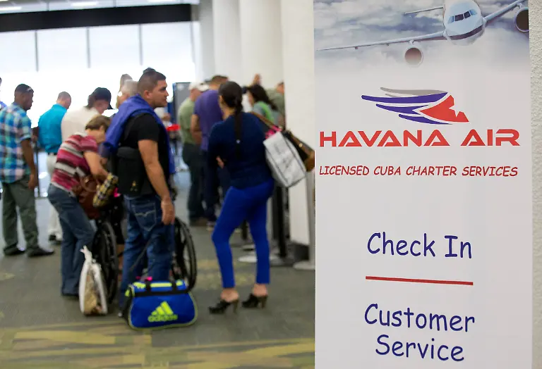 Travelers-line-up-to-check-in-for-charter-flights-from-Miami-to-Havana-at-Miami-International-Airport-Friday-Jan-16-2015-in-Miami-Following-through-on-its-declaration-of-warming-ties-with-Cuba-the-Obama-administration-has-eased-travel-restrictions-and-opened-a-wide-range-of-new-export-opportunities-with-the-communist-island