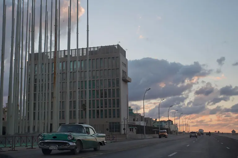 FILE-This-Dec-17-2014-file-photo-shows-a-classic-American-car-driving-past-the-U-S-Interests-Section-buidling-in-Havana-Cuba-A-half-century-after-Washington-severed-relations-with-Cuba-the-seven-story-mission-is-set-to-become-a-full-fledged-embassy-The-U-S-and-Cuba-announced-on-Dec-17-2014-they-are-re-establishing-full-diplomatic-relations