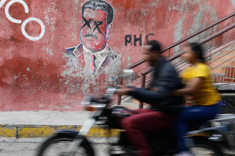 A-motorcyclist-rides-past-graffiti-depicting-former-Venezuelan-President-Nicolas-Maduro-who-is-facing-trial-in-the-United-States-after-U-S-forces-captured-him-in-Caracas-Venezuela-Sunday-Jan-11-2026