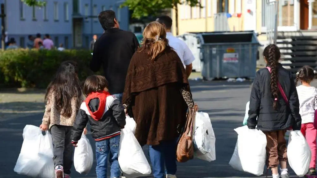 Eine-Familie-wird-in-einer-Erstaufnahmeeinrichtung-fuer-Fluechtlinge-zu-ihrer-Unterkunft-geleitet