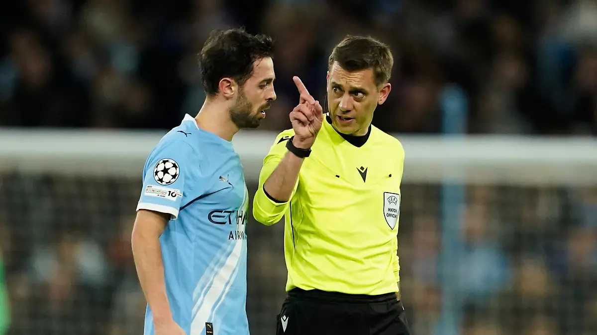 Referee-Clement-Turpin-talks-with-Manchester-City-s-Bernardo-Silva-before-checking-the-VAR-for-a-red-card-during-the-Champions-League-round-of-16-second-leg-soccer-match-between-Manchester-City-and-Real-Madrid-in-Manchester-Tuesday-March-17-2026