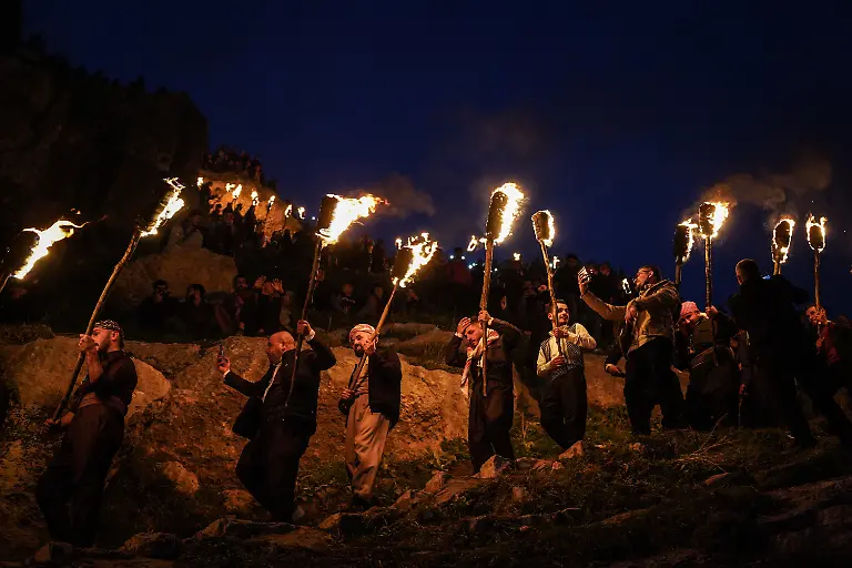 Irakisch-kurdische-Maenner-halten-Fackeln-in-der-Hand-waehrend-sie-anlaesslich-der-Feierlichkeiten-zum-kurdischen-Neujahrsfest-Newroz-auf-einem-Berg-stehen