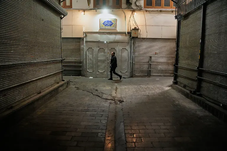 Ein-Mann-geht-an-geschlossenen-Geschaeften-auf-dem-fast-leeren-traditionellen-Tajrish-Basar-im-Norden-Teherans-vorbei