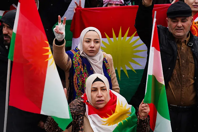January-30-2026-Duhok-Iraq-Kurdish-women-hold-national-flags-during-a-demonstration-at-Newroz-Square-in-solidarity-with-the-Kurdish-people-of-Rojava-northeast-Syria-Cities-across-the-Kurdistan-Region-witnessed-demonstrations-condemning-the-recent-military-escalation-and-the-siege-imposed-by-Syrian-regime-forces-on-Kurdish-held-areas-in-Rojava-northeast-Syria-Waving-Kurdish-flags-demonstrators-gathered-in-large-crowds-and-called-on-the-international-community-and-the-United-Nations-to-intervene-to-protect-civilians