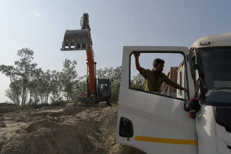 An-abandoned-pit-is-being-filled-with-fly-ash-and-overburden-at-the-Bishrampur-open-cast-mining-area-in-Surajpur-India-November-17-2025-Bishrampur-stands-as-a-model-for-India-s-attempts-to-give-its-exhausted-mines-a-second-life-as-the-world-s-second-largest-coal-producer-and-consumer-after-China-is-accelerating-regeneration-programmes-across-hundreds-of-mines-as-their-coal-runs-out-aiming-to-create-sustainable-livelihoods-for-the-communities-who-live-there-mostly-from-tourism-Spread-across-1-472-hectares-5-68-square-miles-the-Bishrampur-mine-s-10-pits-yielded-more-than-38-7-million-tons-of-coal-between-1961-and-2018-when-the-coal-finally-ran-out-REUTERS-Avijit-Ghosh-SEARCH-INDIA-GHOSH-COAL-FOR-THIS-STORY-SEARCH-WIDER-IMAGE-FOR-ALL-STORIES