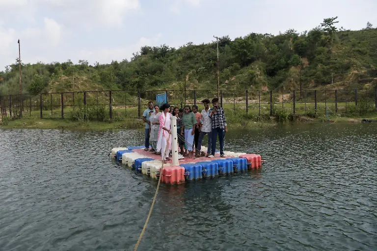 Savita-Gupta-28-brings-tourists-on-a-makeshift-boat-to-the-floating-restaurant-run-by-a-self-help-group-that-she-is-part-of-at-Kenapara-Eco-Park-which-was-developed-from-a-closed-open-cast-coal-mine-pit-into-a-small-tourist-hub-in-Surajpur-India-August-10-2025-The-site-which-began-to-be-repurposed-for-tourism-in-2018-is-managed-by-a-women-s-community-group-and-a-fishery-cooperative-and-attracts-as-many-as-150-people-at-the-weekend-and-for-the-women-the-gains-have-gone-beyond-income-I-hope-my-daughter-will-learn-from-my-life-and-think-about-becoming-an-independent-woman-Gupta-said-REUTERS-Avijit-Ghosh-SEARCH-INDIA-GHOSH-COAL-FOR-THIS-STORY-SEARCH-WIDER-IMAGE-FOR-ALL-STORIES