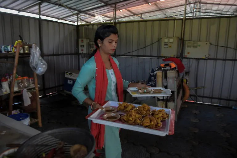 Savita-Gupta-28-carries-fries-and-snacks-for-customers-at-the-floating-restaurant-at-Kenapara-Eco-Park-which-was-developed-from-a-closed-open-cast-coal-mine-pit-into-a-small-tourist-hub-in-Surajpur-India-November-16-2025-The-site-which-began-to-be-repurposed-for-tourism-in-2018-is-managed-by-a-women-s-community-group-and-a-fishery-cooperative-and-attracts-as-many-as-150-people-at-the-weekend-and-for-the-women-the-gains-have-gone-beyond-income-I-hope-my-daughter-will-learn-from-my-life-and-think-about-becoming-an-independent-woman-Gupta-said-REUTERS-Avijit-Ghosh-SEARCH-INDIA-GHOSH-COAL-FOR-THIS-STORY-SEARCH-WIDER-IMAGE-FOR-ALL-STORIES