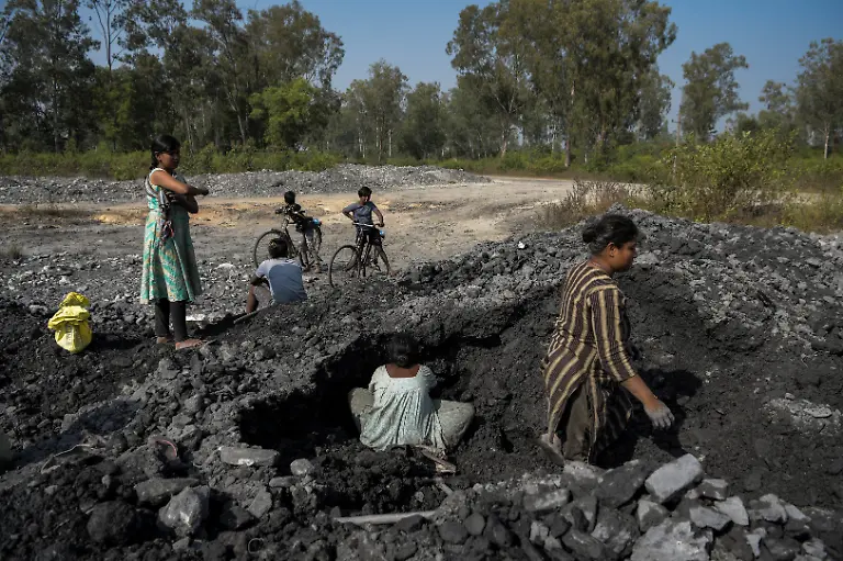 People-collect-leftover-shale-coal-near-a-closed-pit-that-is-being-filled-with-fly-ash-and-overburden-at-the-Bishrampur-OC-mining-area-in-Surajpur-India-November-17-2025-Bishrampur-stands-as-a-model-for-India-s-attempts-to-give-its-exhausted-mines-a-second-life-as-the-world-s-second-largest-coal-producer-and-consumer-after-China-is-accelerating-regeneration-programmes-across-hundreds-of-mines-as-their-coal-runs-out-aiming-to-create-sustainable-livelihoods-for-the-communities-who-live-there-mostly-from-tourism-Spread-across-1-472-hectares-5-68-square-miles-the-Bishrampur-mine-s-10-pits-yielded-more-than-38-7-million-tons-of-coal-between-1961-and-2018-when-the-coal-finally-ran-out-REUTERS-Avijit-Ghosh-SEARCH-INDIA-GHOSH-COAL-FOR-THIS-STORY-SEARCH-WIDER-IMAGE-FOR-ALL-STORIES