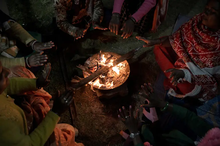 Women-from-the-Shiv-Shakti-Mahila-Gram-Sangathan-self-help-group-sit-in-a-circle-and-warm-their-hands-by-a-fire-after-their-shifts-ended-at-Kenapara-Eco-Park-which-was-developed-from-a-closed-open-cast-coal-mine-pit-into-a-small-tourist-hub-in-Surajpur-India-November-16-2025-The-site-which-began-to-be-repurposed-for-tourism-in-2018-is-managed-by-a-women-s-community-group-and-a-fishery-cooperative-and-attracts-as-many-as-150-people-at-the-weekend-and-for-the-women-the-gains-have-gone-beyond-income-Here-women-are-known-by-the-name-of-their-husband-or-father-in-law-We-wanted-to-be-known-by-our-own-names-the-group-s-leader-Pooja-Sahu-said-REUTERS-Avijit-Ghosh-SEARCH-INDIA-GHOSH-COAL-FOR-THIS-STORY-SEARCH-WIDER-IMAGE-FOR-ALL-STORIES