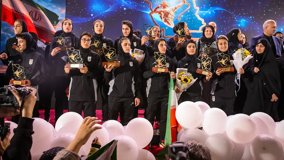 dpatopbilder-19-03-2026-Iran-Teheran-Spielerinnen-und-Mitglieder-der-iranischen-Frauenfussballnationalmannschaft-stehen-auf-der-Buehne-waehrend-einer-Empfangszeremonie-nach-ihrer-Teilnahme-am-AFC-Women-s-Asian-Cup-in-Australien