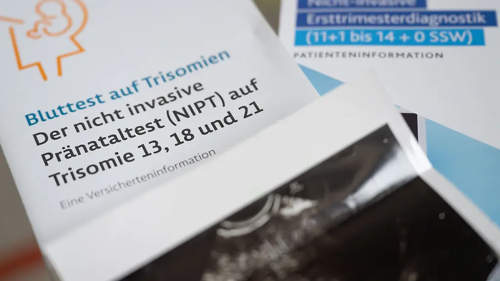 Zwei-Informationsbroschueren-zu-nichtinvasiven-Praenataltests-liegen-neben-einem-Ultraschallbild-in-einer-Frauenarztpraxis-Der-Bundestag-debattiert-heute-ueber-Bluttests-bei-Schwangeren-auf-ein-Down-Syndrom-des-Kindes-die-seit-2022-auf-Kassenkosten-moeglich-sind
