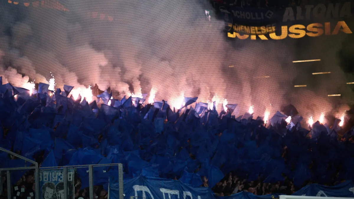 21-03-2026-Nordrhein-Westfalen-Dortmund-Fussball-Maenner-Bundesliga-Borussia-Dortmund-Hamburger-SV-27-Spieltag-Signal-Iduna-Park-HSV-Fans-brennen-Pyrotechnik-ab-Foto-Bernd-Thissen-dpa-WICHTIGER-HINWEIS-Gemaess-den-Vorgaben-der-DFL-Deutsche-Fussball-Liga-bzw-des-DFB-Deutscher-Fussball-Bund-ist-es-untersagt-in-dem-Stadion-und-oder-vom-Spiel-angefertigte-Fotoaufnahmen-in-Form-von-Sequenzbildern-und-oder-videoaehnlichen-Fotostrecken-zu-verwerten-bzw-verwerten-zu-lassen