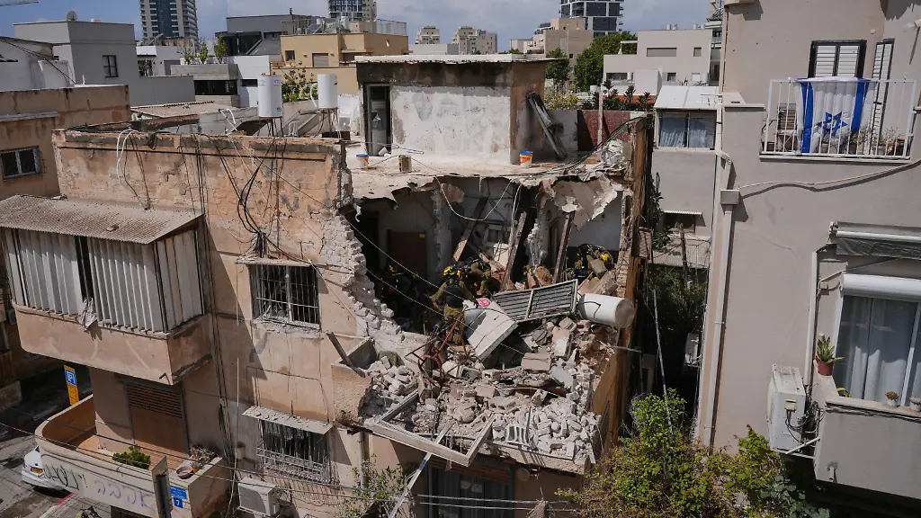 Israeli-Home-Front-Command-officers-inspect-an-apartment-building-struck-by-an-Iranian-missile-in-Tel-Aviv-Israel-Sunday-March-22-2026