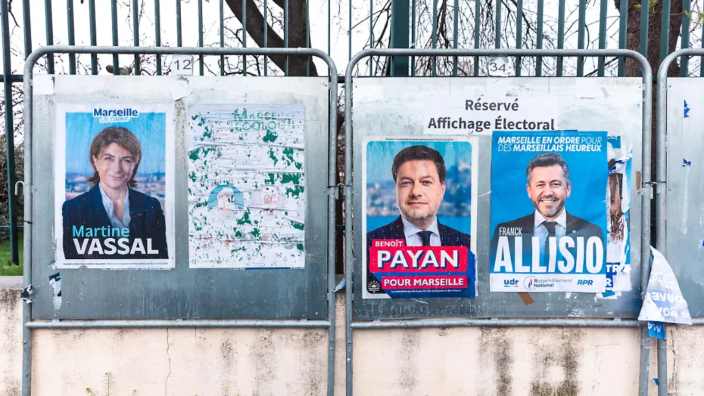 An-election-billboard-displaying-campaign-posters-for-Martine-Vassal-the-candidate-for-the-Union-of-the-Right-and-Center-Benoit-Payan-mayor-of-Marseille-since-2020-and-the-lead-candidate-on-the-2026-municipal-election-ticket-for-the-left-wing-coalition-Printemps-Marseillais-and-Franck-Allisio-the-far-right-candidate-for-the-National-Rally-in-Marseille-in-the-Bouches-du-Rhone-department-in-southeastern-France-on-March-22-2026-The-slogans-Marseille-Je-t-aime-Marseille-I-love-you-Pour-Marseille-For-Marseille-and-Marseille-en-ordre-Marseille-in-command-along-with-the-side-by-side-placement-of-the-posters-illustrate-the-visual-competition-in-the-2026-municipal-election-campaign-in-public-spaces-Un-panneau-d-affichage-electoral-ou-sont-colles-des-affiches-de-campagne-de-Martine-Vassal-candidate-pour-l-union-de-la-droite-et-du-centre-de-Benoit-Payan-maire-de-Marseille-depuis-2020-et-tete-de-liste-aux-elections-municipales-de-2026-pour-la-coalition-de-gauche-Printemps-Marseillais-et-de-Franck-Allisio-candidat-d-extreme-droite-du-Rassemblement-National-a-Marseille-dans-le-departement-des-Bouches-du-Rhone-dans-le-sud-est-de-la-France-le-22-mars-2026-Les-slogans-Marseille-Je-t-aime-Pour-Marseille-et-Marseille-en-ordre-ainsi-que-la-disposition-cote-a-cote-des-affiches-illustrent-la-concurrence-visuelle-de-la-campagne-des-elections-municipales-2026-dans-l-espace-public