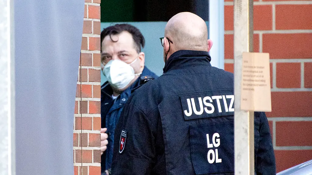 08-03-2022-Niedersachsen-Oldenburg-Der-wegen-Mordes-verurteilte-Niels-Hoegel-wird-vor-Prozessbeginn-durch-einen-Nebeneingang-in-die-Weser-Ems-Hallen-gefuehrt-in-die-das-Landgericht-aus-Platzgruenden-den-Prozess-gegen-fruehere-Vorgesetzte-des-ehemaligen-Krankenpflegers-an-den-Kliniken-Oldenburg-und-Delmenhorst-verlegt-hat-Der-2019-wegen-85-Morden-verurteilte-Hoegel-soll-als-Zeuge-aussagen-Wegen-der-Mordserie-muessen-sich-Vorgesetzte-des-Ex-Krankenpflegers-der-Kliniken-Oldenburg-und-Delmenhorst-vor-Gericht-verantworten