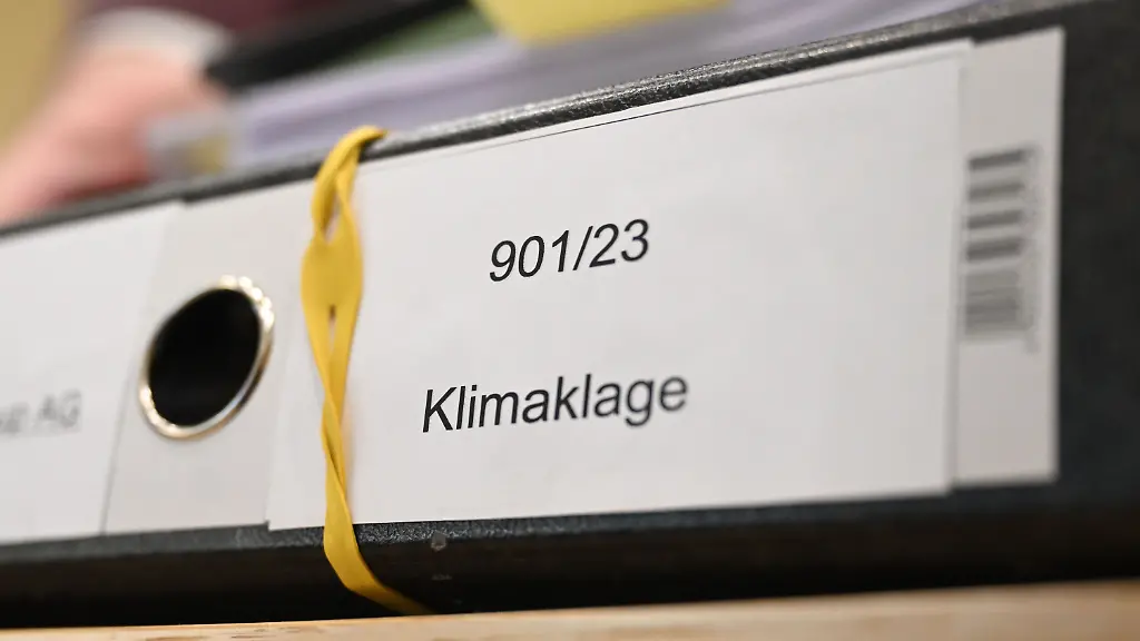 Ein-Aktenordner-mit-der-Aufschrift-Klimaklage-liegt-in-einem-Sitzungssaal-des-Bundesgerichtshofs-BGH-auf-einem-Tisch-Die-Deutsche-Umwelthilfe-klagt-vor-dem-BGH-gegen-BMW-und-Mercedes-Benz-Sie-fordert-unter-anderem-dass-die-Dax-Konzerne-ab-November-2030-keine-herkoemmlichen-Verbrenner-mehr-verkaufen-duerfen-die-Treibhausgase-ausstossen