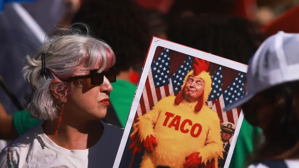 A-demonstrator-holds-an-illustration-of-U-S-President-Donald-Trump-wearing-a-chicken-costume-during-a-protest-against-the-50-U-S-tariff-on-Brazilian-goods-outside-the-U-S-consulate-in-Brasilia-Friday-Aug-1-2025
