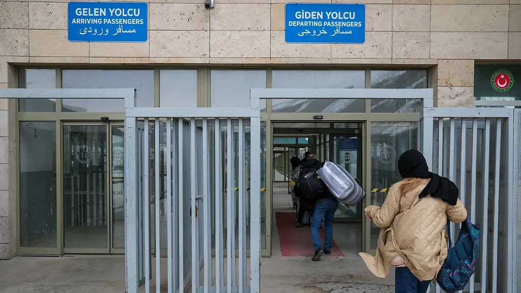 A-woman-runs-at-the-border-crossing-Movement-continues-at-the-Kapikoy-Border-Gate-in-in-Van-Turkey-on-March-14-2026-as-cross-border-movement-continues-in-a-controlled-manner-amid-the-war-that-began-after-the-United-States-and-Israel-attacked-Iran-with-travelers-moving-in-both-directions-and-some-countries-evacuating-citizens-through-the-crossing-Turkey-has-three-border-crossings-with-Iran-Gurbulak-in-Agri-Kapikoy-in-Van-and-Esendere-in-Hakkari